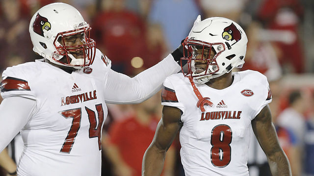 HOUSTON, TX - NOVEMBER 17: Offensive lineman Geron Christian #74 taps the head of quarterback Lamar Jackson #8 of the Louisville Cardinals while he walks off the field against the Houston Cougars in the second quarter at TDECU Stadium on November 17, 2016 in Houston, Texas.