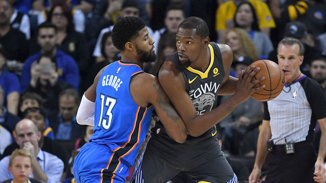 OAKLAND, CA - FEBRUARY 06: Kevin Durant #35 of the Golden State Warriors looks to shoot while guarded closely by Paul George #13 of the Oklahoma City Thunder during the first half of their NBA basketball game at ORACLE Arena on February 6, 2018 in Oakland, California.