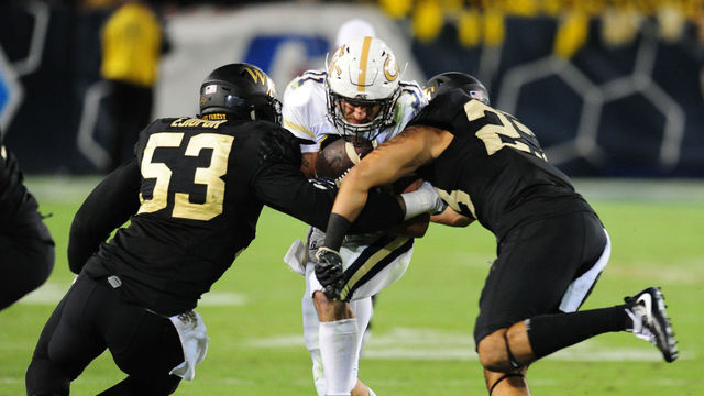 ATLANTA, GA - OCTOBER 21: Nathan Cottrell #31 of the Georgia Tech Yellow Jackets drives for yardage against Duke Ejiofor #53 and Justin Stmad #23 of the Wake Forest Deamon Deacons on October 21, 2017 at Bobby Dodd Stadium in Atlanta, Georgia.