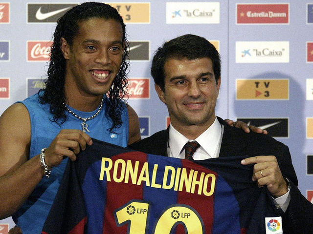 Barcelona's new Brazilian soccer star Ronaldinho (L) and Barcelona newly-elected president Joan Laporta (R) hold Ronaldinho 's jersey during his official presentation at the Nou Camp Stadium in Barcelona, 21 July 2003. AFP PHOTO JOSE JORDAN