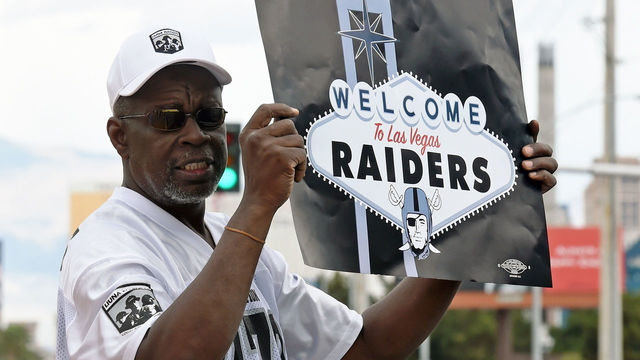 LAS VEGAS, NV - MARCH 27: Oakland Raiders fan Davi Tole of Nevada displays a sign to passing motorists on the Las Vegas Strip near the Welcome to Fabulous Las Vegas sign after National Football League owners voted 31-1 to approve the team's application to relocate to Las Vegas during their annual meeting on March 27, 2017 in Las Vegas, Nevada. The Raiders are expected to begin play no later than 2020 in a planned 65,000-seat domed stadium to be built in Las Vegas at a cost of about USD 1.9 billion.