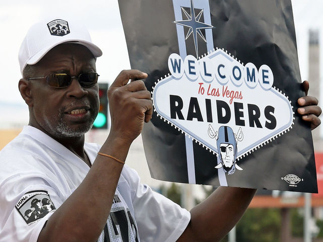 LAS VEGAS, NV - MARCH 27: Oakland Raiders fan Davi Tole of Nevada displays a sign to passing motorists on the Las Vegas Strip near the Welcome to Fabulous Las Vegas sign after National Football League owners voted 31-1 to approve the team's application to relocate to Las Vegas during their annual meeting on March 27, 2017 in Las Vegas, Nevada. The Raiders are expected to begin play no later than 2020 in a planned 65,000-seat domed stadium to be built in Las Vegas at a cost of about USD 1.9 billion.