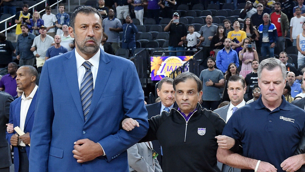 LAS VEGAS, NV - OCTOBER 08: (L-R) Vice president of basketball operations and general manager of the Sacramento Kings Vlade Divac, Sacramento Kings owner Vivek Ranadive, MGM Resorts International Chairman and CEO Jim Murren, controlling owner and President of the Los Angeles Lakers Jeanie Buss, AEG Senior Vice President, Global Partnerships, Mark Faber and Los Angeles Lakers president of basketball operations Earvin 'Magic' Johnson lock arms as Johnson asks the crowd for a moment of silence to honor victims of last Sunday's mass shooting before a Kings-Lakers preseason game at T-Mobile Arena on October 8, 2017 in Las Vegas, Nevada. On October 1, Stephen Paddock killed at least 58 people and injured more than 450 after he opened fire on a large crowd at the Route 91 Harvest country music festival. The massacre is one of the deadliest mass shooting events in U.S. history. Los Angeles won 75-69.