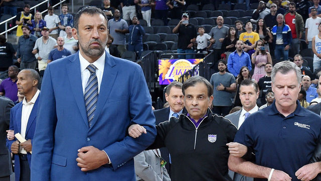 LAS VEGAS, NV - OCTOBER 08: (L-R) Vice president of basketball operations and general manager of the Sacramento Kings Vlade Divac, Sacramento Kings owner Vivek Ranadive, MGM Resorts International Chairman and CEO Jim Murren, controlling owner and President of the Los Angeles Lakers Jeanie Buss, AEG Senior Vice President, Global Partnerships, Mark Faber and Los Angeles Lakers president of basketball operations Earvin 'Magic' Johnson lock arms as Johnson asks the crowd for a moment of silence to honor victims of last Sunday's mass shooting before a Kings-Lakers preseason game at T-Mobile Arena on October 8, 2017 in Las Vegas, Nevada. On October 1, Stephen Paddock killed at least 58 people and injured more than 450 after he opened fire on a large crowd at the Route 91 Harvest country music festival. The massacre is one of the deadliest mass shooting events in U.S. history. Los Angeles won 75-69.