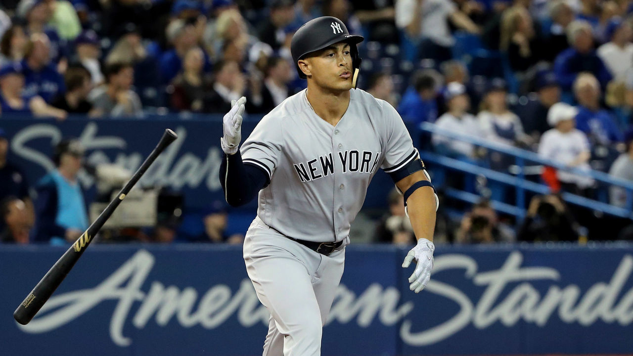 TORONTO, ON - MARCH 29: Giancarlo Stanton #27 of the New York Yankees reacts as he hits a solo home run in the ninth inning on Opening Day during MLB game action against the Toronto Blue Jays at Rogers Centre on March 29, 2018 in Toronto, Canada.