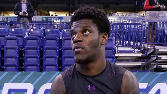 INDIANAPOLIS, IN - MARCH 03: Louisville quarterback Lamar Jackson looks on while talking to Clemson wide receivers Deon Cain (left) and Ray-Ray McCloud (right) during the NFL Combine at Lucas Oil Stadium on March 3, 2018 in Indianapolis, Indiana.