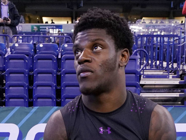 INDIANAPOLIS, IN - MARCH 03: Louisville quarterback Lamar Jackson looks on while talking to Clemson wide receivers Deon Cain (left) and Ray-Ray McCloud (right) during the NFL Combine at Lucas Oil Stadium on March 3, 2018 in Indianapolis, Indiana.