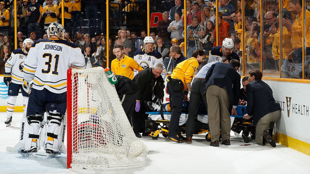 NASHVILLE, TN - MARCH 31: Goalie Chad Johnson #31 looks on as medical staff tend to Victor Antipin #93 of the Buffalo Sabres after a hit by Scott Hartnell #17 of the Nashville Predators during an NHL game at Bridgestone Arena on March 31, 2018 in Nashville, Tennessee.