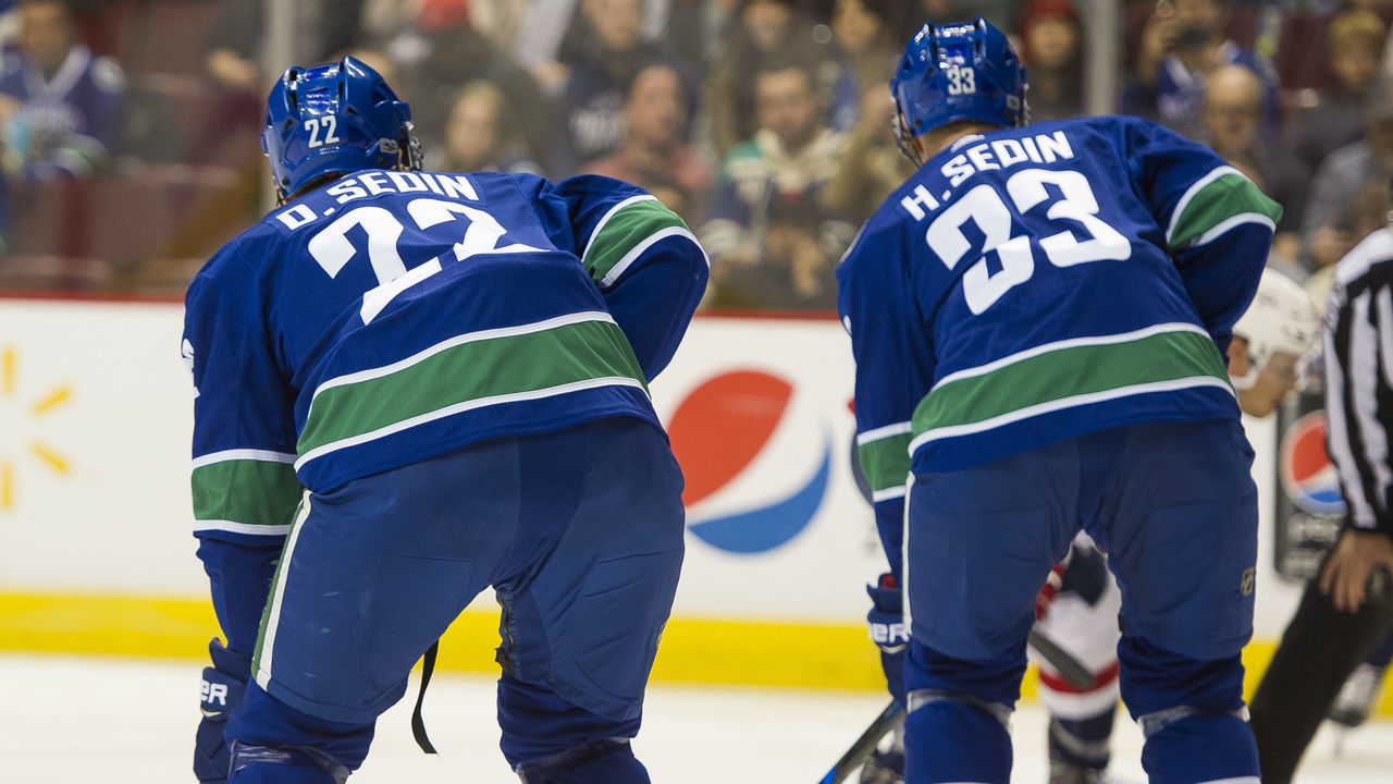 VANCOUVER, BC - OCTOBER 26: Brothers Daniel Sedin #22 and Henrik Sedin #33 of the Vancouver Canucks line up for a face off during NHL action against the Washington Capitals on October, 26, 2017 at Rogers Arena in Vancouver, British Columbia, Canada.