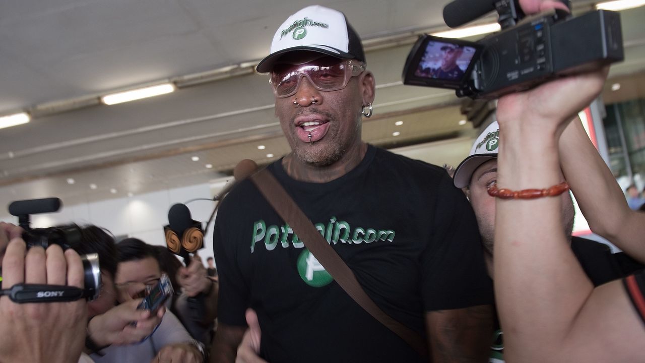 Former NBA basketball player Dennis Rodman (C) of the US walks out from the arrival gate returning from his trip to North Korea at Beijing's international airport on June 17, 2017. / AFP PHOTO / NICOLAS ASFOURI