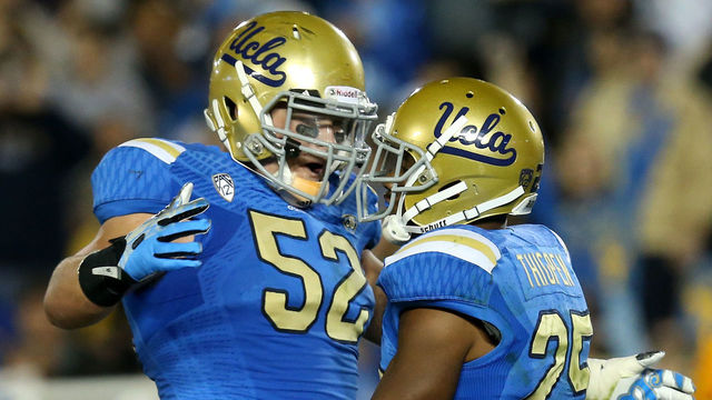 PASADENA, CA - NOVEMBER 02: Running back Damien Thigpen #25 and guard Scott Quessenberry #52 of the UCLA Bruins celebrate after Thigpen's five yard touchdown carry in the the third quarter against the Colorado Buffaloes at the Rose Bowl on November 2, 2013 in Pasadena, California. UCLA won 45-23.