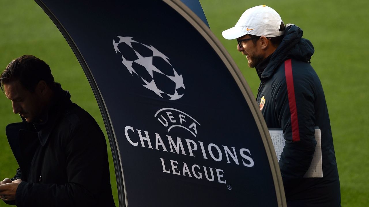 Roma's Italian head coach Eusebio Di Francesco (R) and former player Francesco Totti stand by a Champions League logo during a training session at The Camp Nou Stadium in Barcelona on April 3, 2018, on the eve of the UEFA Champions League quarter-final football match between Barcelona and Roma. / AFP PHOTO / FILIPPO MONTEFORTE