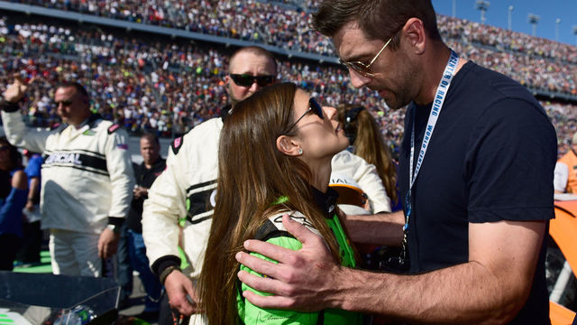 DAYTONA BEACH, FL - FEBRUARY 18: Danica Patrick, driver of the #7 GoDaddy Chevrolet, stands with Aaron Rodgers, quarterback for the Green Bay Packers, on the grid prior to the Monster Energy NASCAR Cup Series 60th Annual Daytona 500 at Daytona International Speedway on February 18, 2018 in Daytona Beach, Florida.