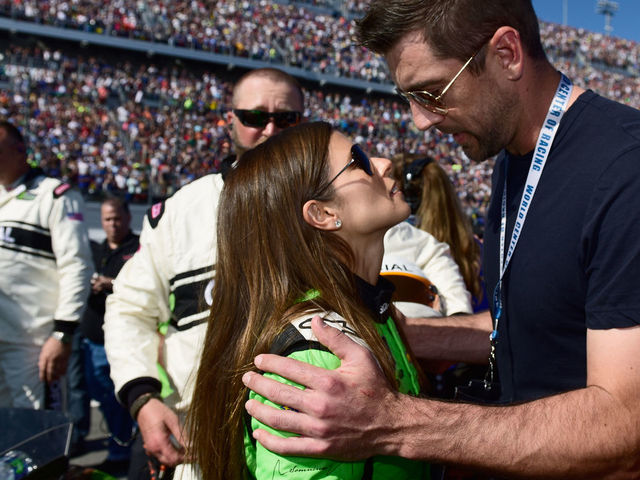 DAYTONA BEACH, FL - FEBRUARY 18: Danica Patrick, driver of the #7 GoDaddy Chevrolet, stands with Aaron Rodgers, quarterback for the Green Bay Packers, on the grid prior to the Monster Energy NASCAR Cup Series 60th Annual Daytona 500 at Daytona International Speedway on February 18, 2018 in Daytona Beach, Florida.
