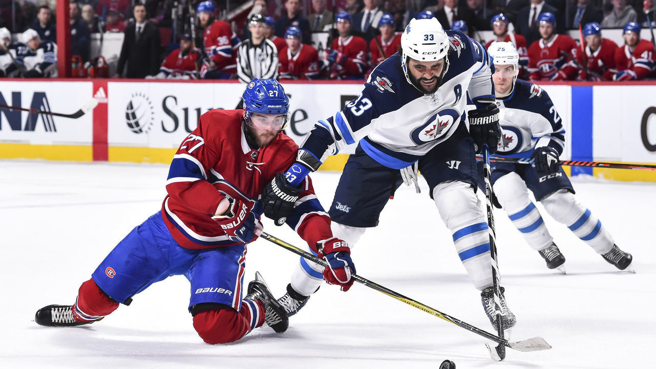 MONTREAL, QC - APRIL 03: Alex Galchenyuk #27 of the Montreal Canadiens and Dustin Byfuglien #33 of the Winnipeg Jets battle for the puck during the NHL game at the Bell Centre on April 3, 2018 in Montreal, Quebec, Canada.