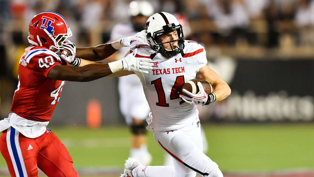LUBBOCK, TX - SEPTEMBER 17: Wide receiver Dylan Cantrell #14 of the Texas Tech Red Raiders tries to break away from cornerback Roland Dunn #40 of the Louisiana Tech Bulldogs during the game on September 17, 2016 at AT&T Jones Stadium in Lubbock, Texas. Texas Tech won the game 59-45.