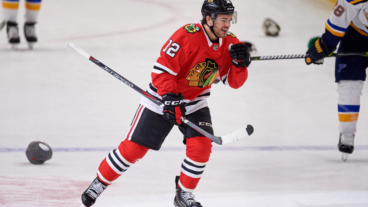 CHICAGO, IL - MARCH 18: Chicago Blackhawks right wing Alex DeBrincat (12) celebrates his third goal with fans and teammates as hats are thrown onto the ice for his hatrick during the game between the Chicago Blackhawks and the St. Louis Blues on March 18, 2018, at the United Center in Chicago, Illinois.
