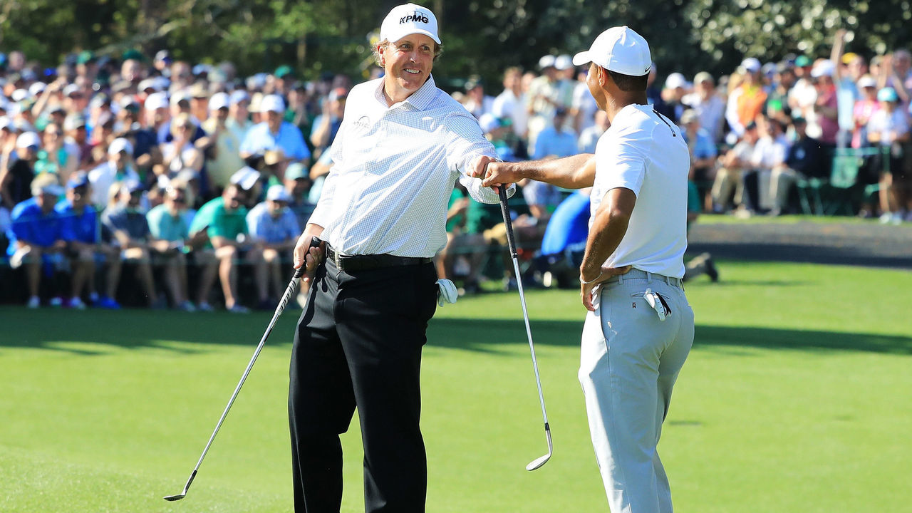 AUGUSTA, GA - APRIL 03: Tiger Woods and Phil Mickelson of the United States fist bump during a practice round prior to the start of the 2018 Masters Tournament at Augusta National Golf Club on April 3, 2018 in Augusta, Georgia.