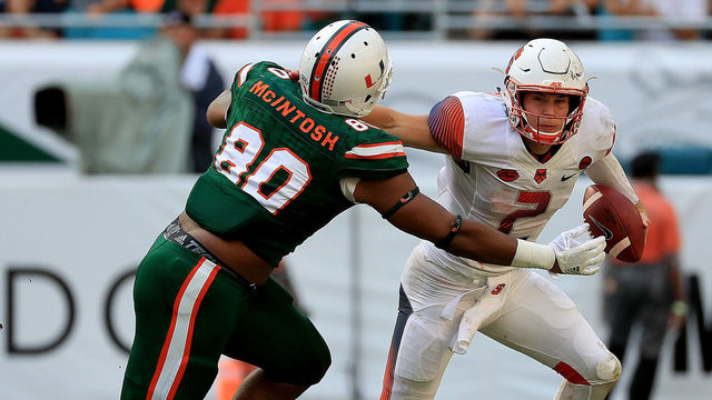 MIAMI GARDENS, FL - OCTOBER 21: Eric Dungey #2 of the Syracuse Orange stiff arms RJ McIntosh #80 of the Miami Hurricanes during a game at Sun Life Stadium on October 21, 2017 in Miami Gardens, Florida.