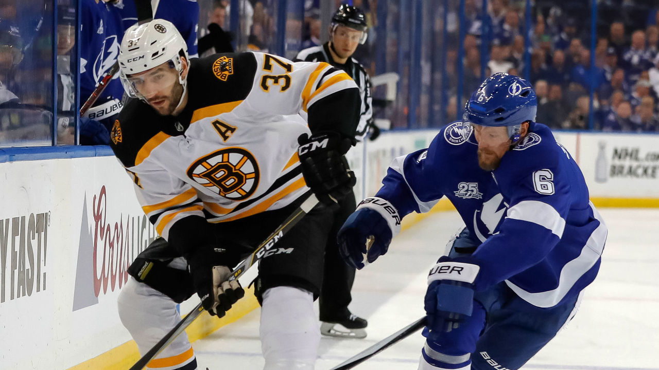TAMPA, FL - APRIL 3: Patrice Bergeron #37 of the Boston Bruins avoids a check from Anton Stralman #6 of the Tampa Bay Lightning during the first period of the game at the Amalie Arena on April 3, 2018 in Tampa, Florida.