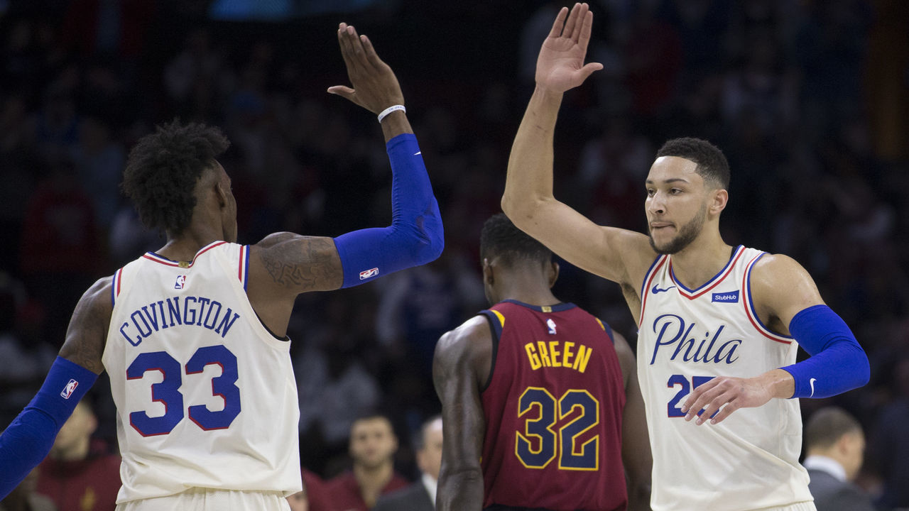 PHILADELPHIA, PA - APRIL 6: Robert Covington #33 and Ben Simmons #25 of the Philadelphia 76ers celebrate in front of Jeff Green #32 of the Cleveland Cavaliers during a timeout in the first quarter at the Wells Fargo Center on April 6, 2018 in Philadelphia, Pennsylvania.