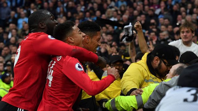 Manchester United's English defender Chris Smalling (R) celebrates scoring their third goal with Manchester United's English defender Manchester United's Belgian striker Romelu Lukaku (L) and Manchester United's English midfielder Jesse Lingard (C) during the English Premier League football match between Manchester City and Manchester United at the Etihad Stadium in Manchester, north west England, on April 7, 2018. / AFP PHOTO / Ben STANSALL /