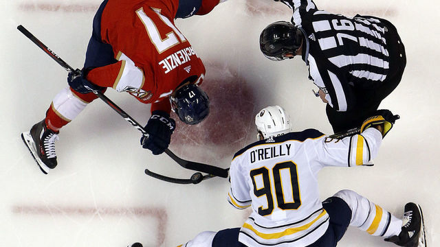 SUNRISE, FL - MARCH 2: NHL Linesmen Michel Cormier #76 drops the puck for a face off between Derek MacKenzie #17 of the Florida Panthers and Ryan O'Reilly #90 of the Buffalo Sabres at the BB&T Center on March 2, 2018 in Sunrise, Florida.