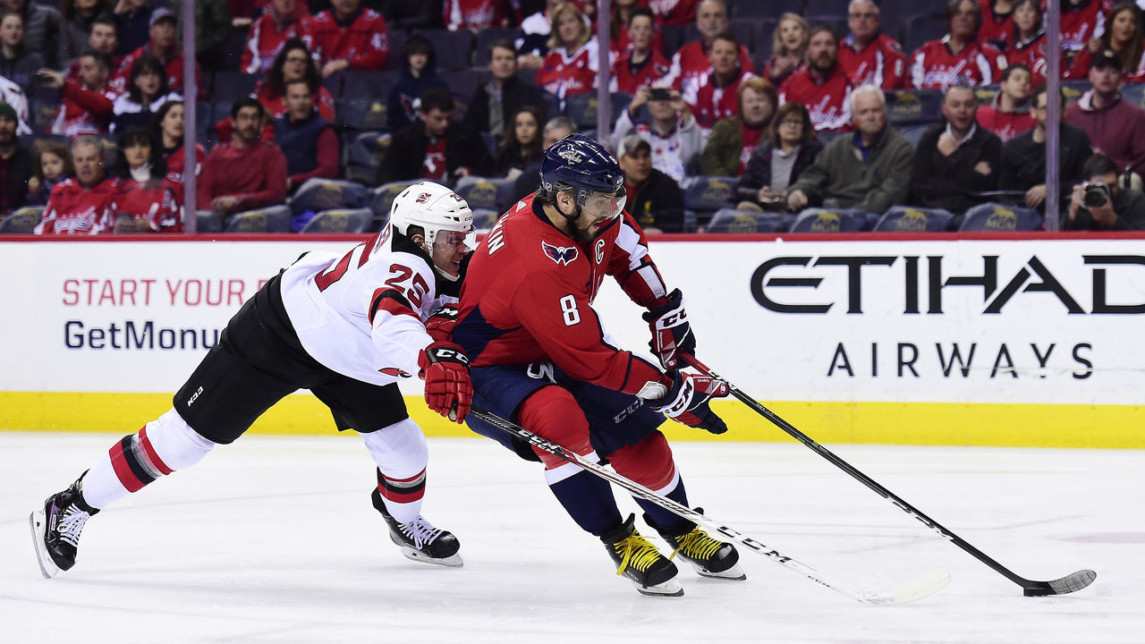 WASHINGTON, DC - APRIL 07: Alex Ovechkin #8 of the Washington Capitals skates with the puck against Mirco Mueller #25 of the New Jersey Devils in the first period at Capital One Arena on April 7, 2018 in Washington, DC.
