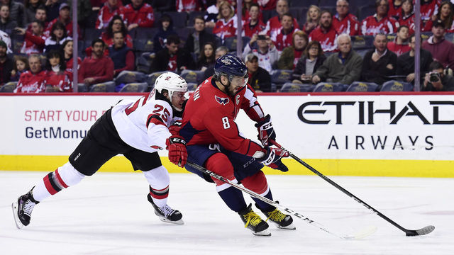WASHINGTON, DC - APRIL 07: Alex Ovechkin #8 of the Washington Capitals skates with the puck against Mirco Mueller #25 of the New Jersey Devils in the first period at Capital One Arena on April 7, 2018 in Washington, DC.