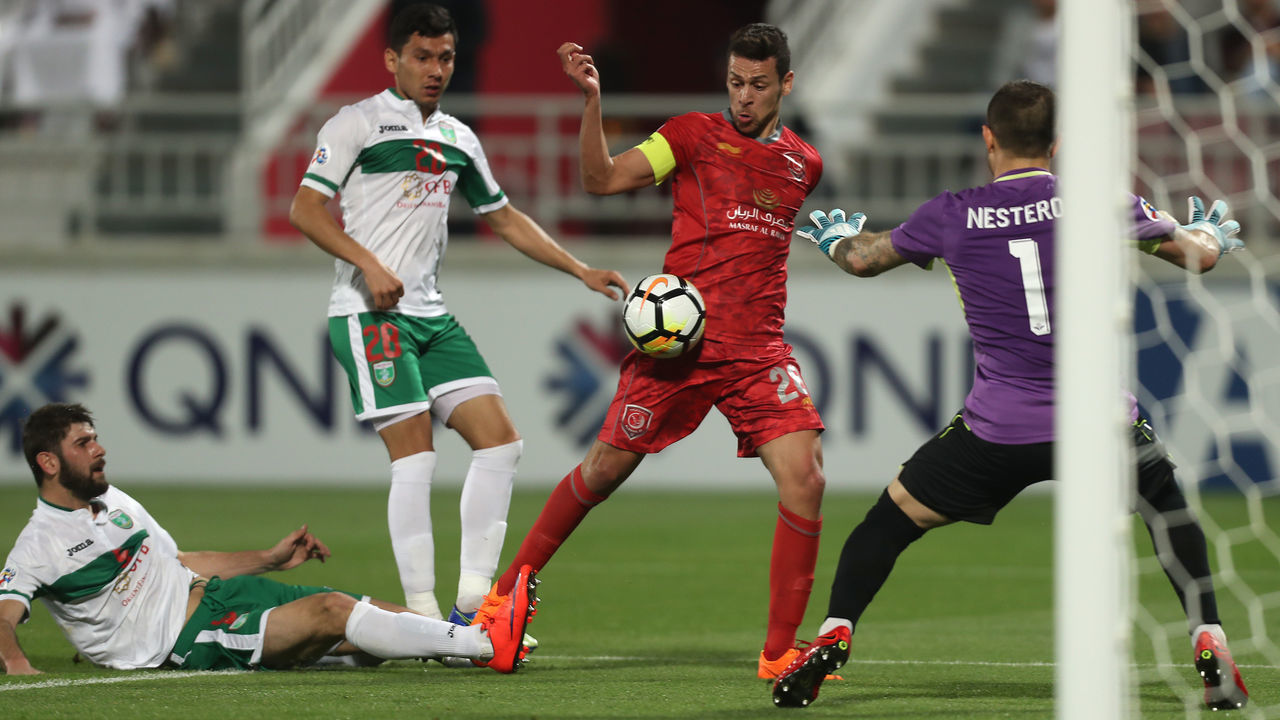 Al-Duhail's Youssef Msakni kicks the ball ahead of Lokomotiv's goalkeeper Ignaty Nesterov during the AFC Champions League football match between Lokomotiv of Uzbekistan and al-Duhail of Qatar at the Abdullah bin khalifa stadium in Doha on March 6, 2018. / AFP PHOTO / KARIM JAAFAR