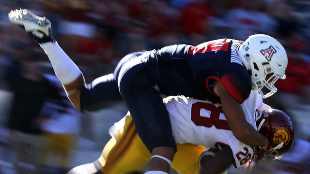 TUCSON, AZ - OCTOBER 15: Cornerback Dane Cruikshank #9 of the Arizona Wildcats tackles running back Aca'Cedric Ware #28 of the USC Trojans during the fourth quarter of the college football game at Arizona Stadium on October 15, 2016 in Tucson, Arizona. USC won 48-14.