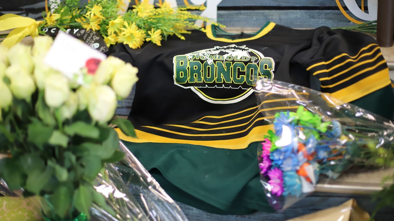 An ice hockey jersey is left in a makeshift memorial at the Humboldt Uniplex in Humboldt, Canada, on April 8, 2018. Canadian Prime Minister Justin Trudeau will attend a vigil late Sunday to honor the victims of a crash that killed 15 people, most of them members of a junior ice hockey team, his office said. The prayer vigil is expected to attract a large crowd in the tiny town of Humboldt, home to some 6,000 people. / AFP PHOTO / Kymber RAE