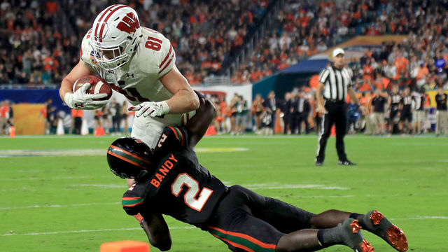 MIAMI GARDENS, FL - DECEMBER 30: Troy Fumagalli #81 of the Wisconsin Badgers is tackled by Trajan Bandy #2 of the Miami Hurricanes during the 2017 Capital One Orange Bowl at Hard Rock Stadium on December 30, 2017 in Miami Gardens, Florida.