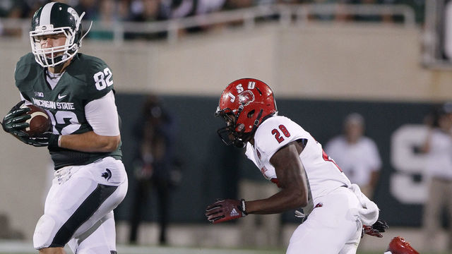 EAST LANSING, MI - AUGUST 29: Tight end Josiah Price #82 of the Michigan State Spartans makes a 32-yard reception against safety Siran Neal #28 of the Jacksonville State Gamecocks during the second half at Spartan Stadium on August 29, 2014 in East Lansing, Michigan. Michigan State defeated Jacksonville State 45-7.