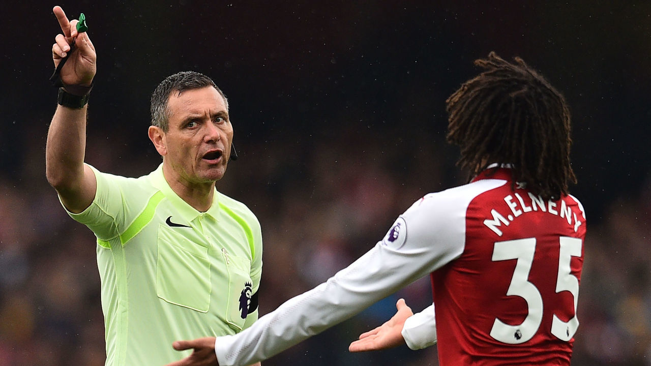 Referee Andre Marriner (L) has words with Arsenal's Egyptian midfielder Mohamed Elneny during the English Premier League football match between Arsenal and Southampton at the Emirates Stadium in London on April 8, 2018. / AFP PHOTO / Glyn KIRK /