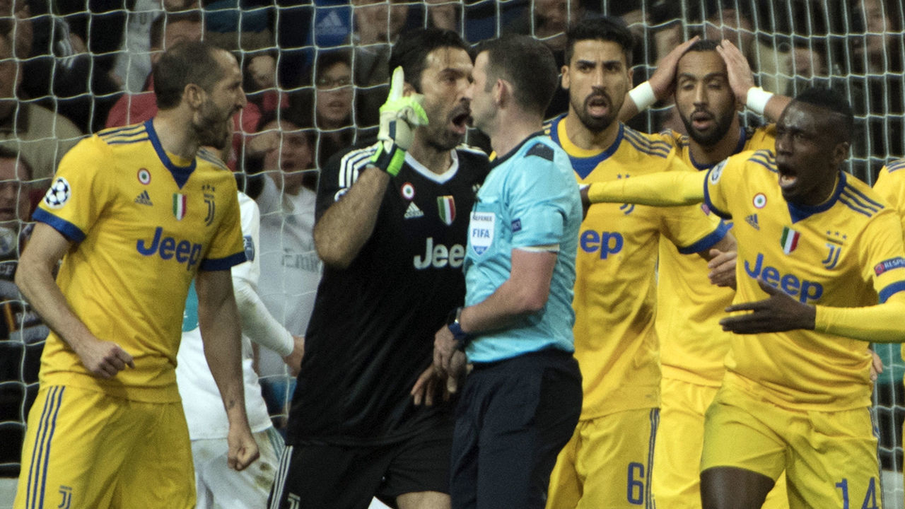 Juventus players protest to English referee Michael Oliver (C) during the UEFA Champions League quarter-final second leg football match between Real Madrid CF and Juventus FC at the Santiago Bernabeu stadium in Madrid on April 11, 2018. / AFP PHOTO / CURTO DE LA TORRE