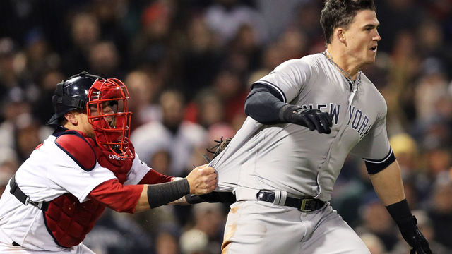 BOSTON, MA - APRIL 11: Christian Vazquez #7 of the Boston Red Sox tries to hold back Tyler Austin #26 of the New York Yankees as he storms the pitchers mound after being stuck by a pitch thrown by Joe Kelly #56 during the seventh inning at Fenway Park on April 11, 2018 in Boston, Massachusetts.
