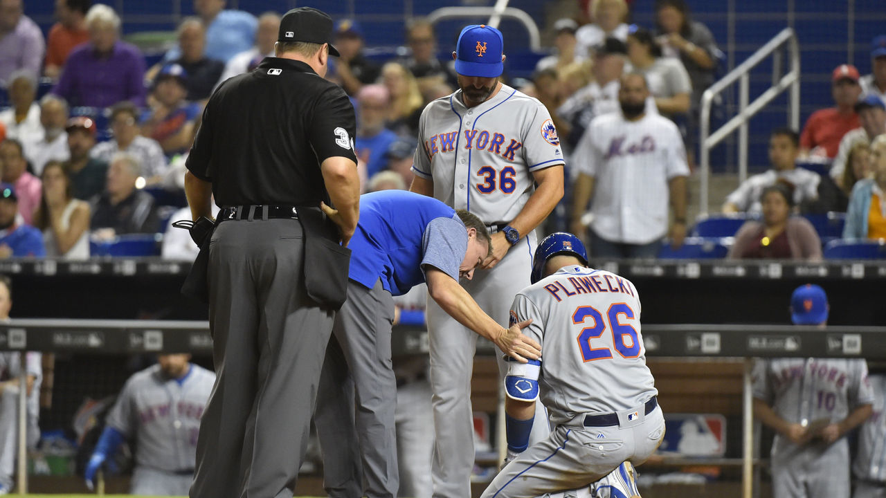MIAMI, FL - APRIL 11: Manager Mickey Callaway #36 of the New York Mets and Head Athletic Trainer Brian Chicklo talk with Kevin Plawecki #26 after he was hit by a pitch in the eighth inning against the Miami Marlins at Marlins Park on April 11, 2018 in Miami, Florida.