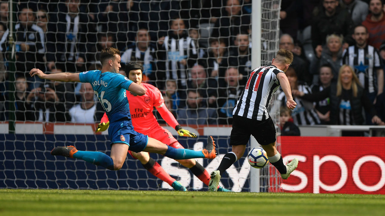 NEWCASTLE UPON TYNE, ENGLAND - APRIL 15: Matt Ritchie of Newcastle United scores his sides second goal past Petr Cech of Arsenal while being challenged by Rob Holding of Arsenal during the Premier League match between Newcastle United and Arsenal at St. James Park on April 15, 2018 in Newcastle upon Tyne, England.