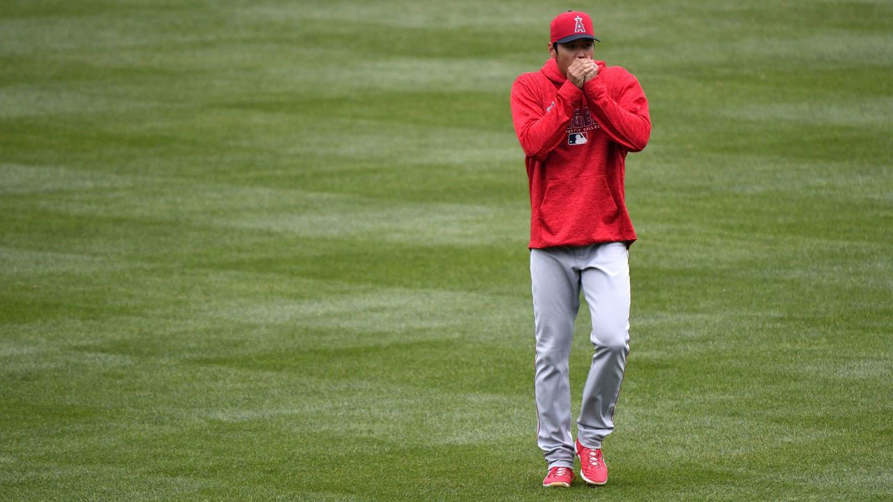 KANSAS CITY, MO - APRIL 14: Shohei Ohtani #17 of the Los Angeles Angels of Anaheim blows in his hands to keep them warm as he stretches out prior to a game against the Kansas City Royals at Kauffman Stadium on April 14, 2018 in Kansas City, Missouri.