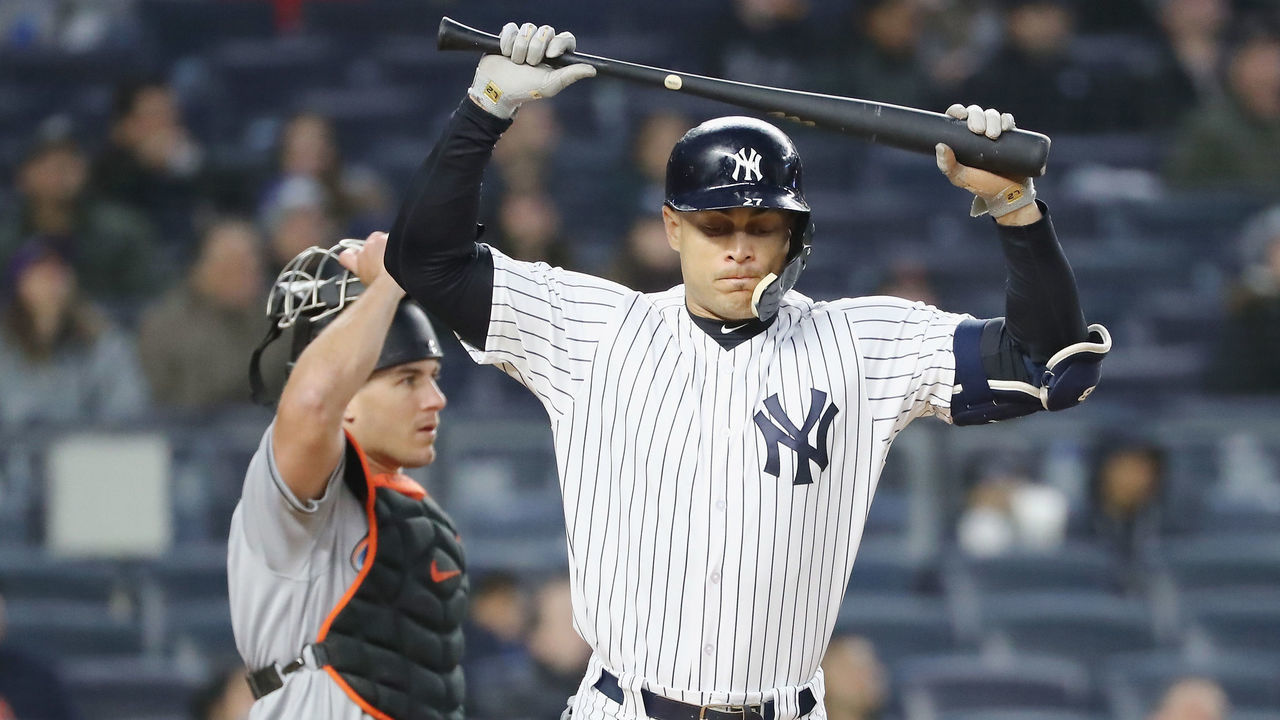 NEW YORK, NY - APRIL 17: Giancarlo Stanton #27 of the New York Yankees reacts after he hit a pop fly in the third inning as J.T. Realmuto #11 of the Miami Marlins defends at Yankee Stadium on April 17, 2018 in the Bronx borough of New York City.