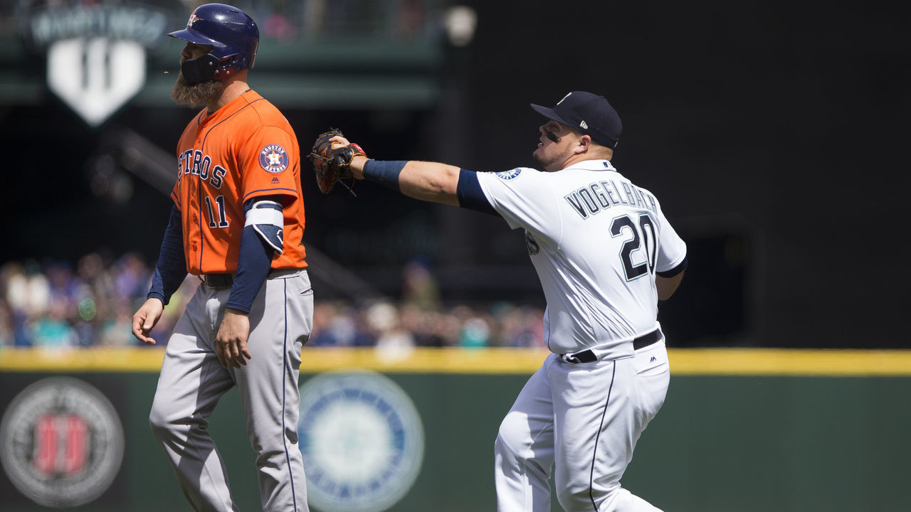 SEATTLE, WA - APRIL 19: Daniel Vogelbach #20 of the Seattle Mariners tags Evan Gattis #11 of the Houston Astros out for a triple play as Gattis walks off the field thinking there were already three outs in the fourth inning at Safeco Field on April 19, 2018 in Seattle, Washington.