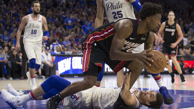 PHILADELPHIA, PA - APRIL 14: Justise Winslow #20 of the Miami Heat controls the ball as Dario Saric #9 of the Philadelphia 76ers reaches for it in the fourth quarter of Game One of the first round of the 2018 NBA Playoff at Wells Fargo Center on April 14, 2018 in Philadelphia, Pennsylvania. The 76ers defeated the Heat 130-103.