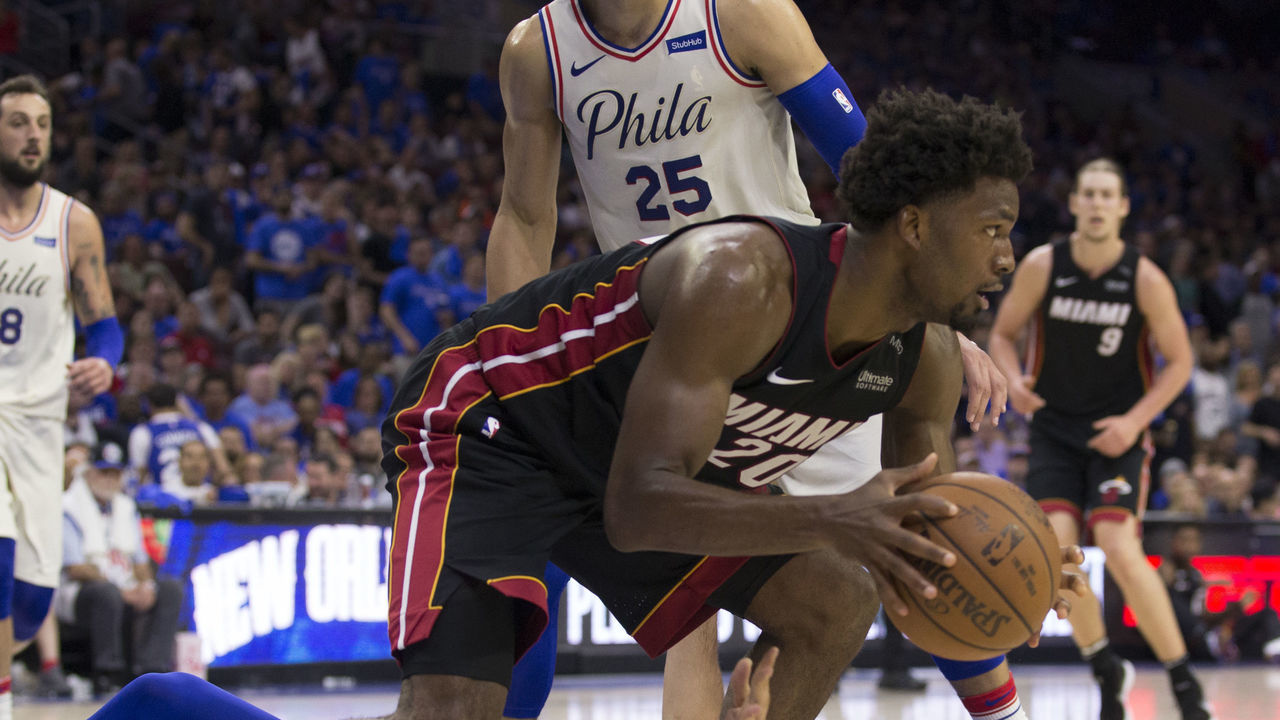 PHILADELPHIA, PA - APRIL 14: Justise Winslow #20 of the Miami Heat controls the ball as Dario Saric #9 of the Philadelphia 76ers reaches for it in the fourth quarter of Game One of the first round of the 2018 NBA Playoff at Wells Fargo Center on April 14, 2018 in Philadelphia, Pennsylvania. The 76ers defeated the Heat 130-103.