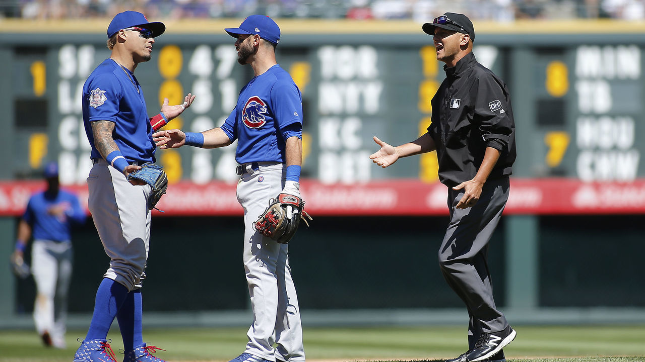 DENVER, CO - APRIL 22: Chicago Cubs infielder Javier Baez (9) is held back by teammate infielder Tommy La Stella (2) during a dispute with second base umpire, Vic Carapazza during a regular season MLB game between the Colorado Rockies and the visiting Chicago Cubs on April 22, 2018 at Coors Field in Denver, CO.