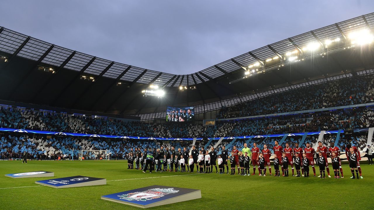 The Manchester City players (L) and the Liverpool players line up on the pitch ahead of the UEFA Champions League second leg quarter-final football match between Manchester City and Liverpool, at the Etihad Stadium in Manchester, north west England on April 10, 2018. Liverpool won the match 2-1. / AFP PHOTO / Paul ELLIS