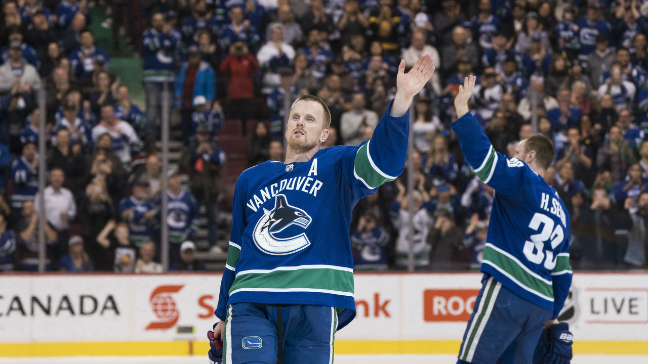 VANCOUVER, BC - OCTOBER 5: Daniel Sedin #22 and Henrik Sedin #33 of the Vancouver Canucks waves to the fans after playing in their final home game of their career against the Arizona Coyotes in NHL action on April, 5, 2018 at Rogers Arena in Vancouver, British Columbia, Canada.