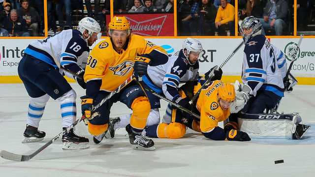 NASHVILLE, TN - MARCH 13: Ryan Hartman #38 and Calle Jarnkrok #19 of the Nashville Predators fight against Bryan Little #18 and Josh Morrissey #44 of the Winnipeg Jets in front of goalie Connor Hellebuyck #37 during the first period at Bridgestone Arena on March 13, 2018 in Nashville, Tennessee.