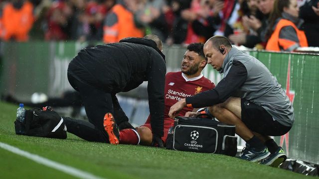 Liverpool's English midfielder Alex Oxlade-Chamberlain (C) picks up an injury during the UEFA Champions League first leg semi-final football match between Liverpool and Roma at Anfield stadium in Liverpool, north west England on April 24, 2018.