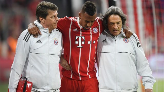 Bayern Munich's German defender Jerome Boateng (C) walks off the pitch with the help of team doctor Hans-Wilhelm Mueller-Wohlfahrt (R)after getting injured during the UEFA Champions League semi-final first-leg football match FC Bayern Munich v Real Madrid CF in Munich in southern Germany on April 25, 2018.